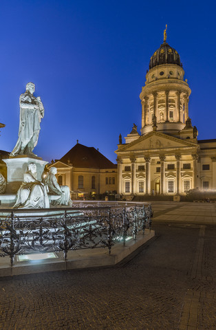 Deutschland, Berlin, beleuchteter Französischer Dom und Statue von Friedrich Schiller am Gendarmenmarkt, lizenzfreies Stockfoto