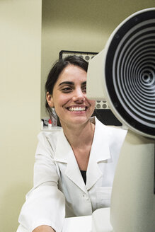 Ophthalmologist smiling, examining eyesight in an ophthalmic clinic - ABZF000799