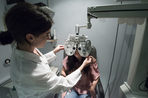 Ophthalmologist adjusting an optometrist phoropter, for eye calibration of a patient stock photo