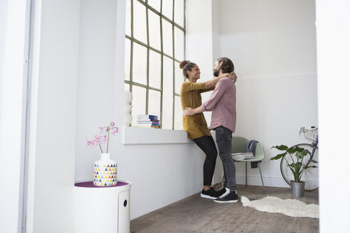 Junges Paar umarmt sich in neuer Wohnung - RBF004606