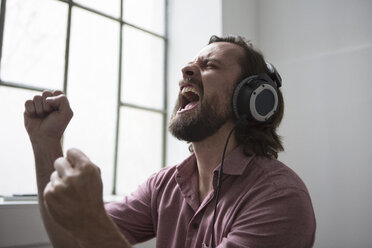 Mann mit Kopfhörern, der zur Musik singt - RBF004632