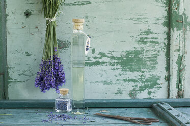Glasflasche mit Lavendelöl, Lavendelbündel und getrocknete Lavendelblüten - ASF005931