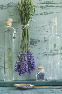 Glasflasche mit Lavendelöl, Lavendelbündel und getrocknete Lavendelblüten - ASF005933