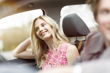 Porträt einer lächelnden blonden Frau auf dem Beifahrersitz in einem Auto - PESF000188