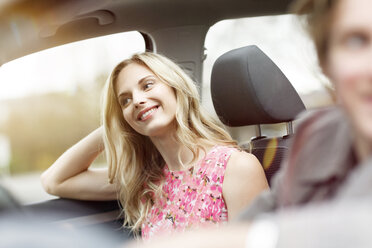 Portrait of smiling blond woman sitting on passenger seat in a car - PESF000188