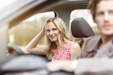 Portrait of smiling blond woman sitting on passenger seat in a car - PESF000189