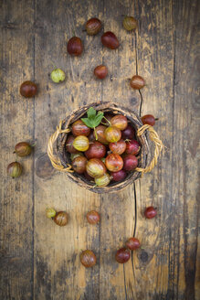 Weidenkorb mit roten Stachelbeeren auf Holz - LVF005087