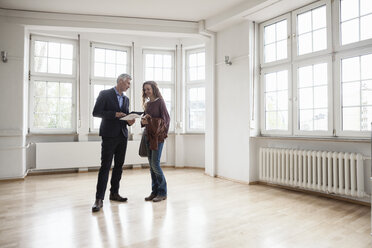 Immobilienmakler im Gespräch mit einem Kunden in einer leeren Wohnung - RBF004679