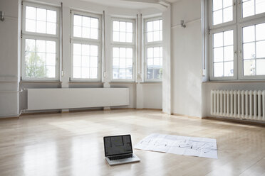 Laptop und Bauplan auf dem Boden einer leeren Wohnung - RBF004705