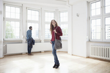 Ehepaar sieht sich in einer leeren Wohnung um - RBF004714