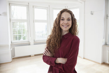 Portrait of smiling woman in empty apartment - RBF004718