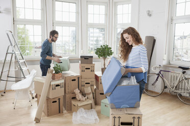 Ehepaar in neuer Wohnung packt Kartons aus - RBF004728