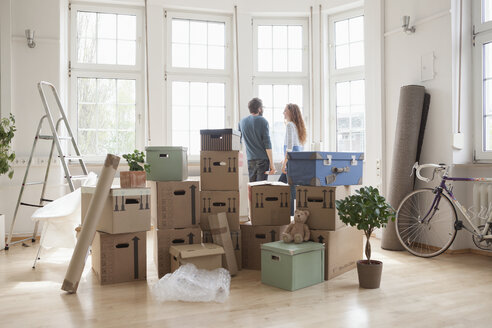 Ehepaar mit Kartons in neuer Wohnung am Fenster - RBF004735