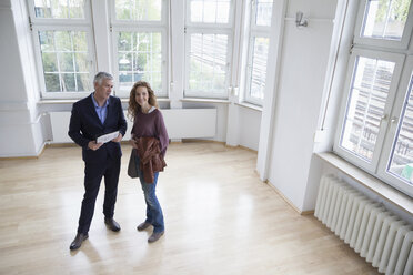 Immobilienmakler im Gespräch mit einem Kunden in einer leeren Wohnung - RBF004740