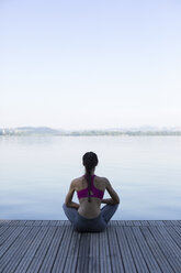 Young woman relaxing after exercises on pier - MRAF000095