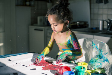 Mädchen malt rotes Bild mit Fingerfarben und ist völlig verschmiert von Farben - YNF000023