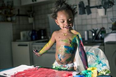 Mädchen malt rotes Bild mit Fingerfarben und ist völlig verschmiert von Farben - YNF000024