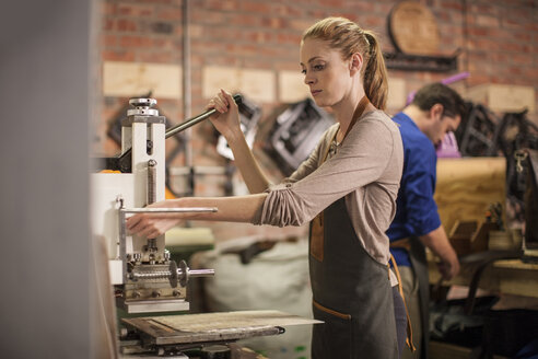 Junge Frau bei der Arbeit in einer Lederwerkstatt - ZEF008954