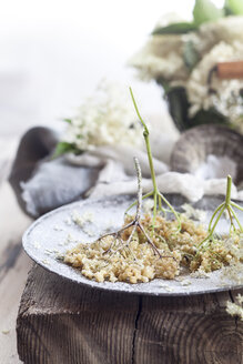 Baked elder flowers with icing sugar on plate - SBDF003014