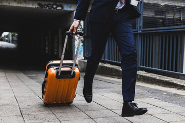 Businessman on business trip running with wheeled luggage - UUF007992