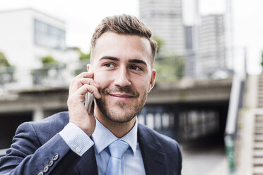 Portrait of a young businessman talking on the phone - UUF008008