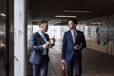 Geschäftsmann, der unterwegs eine Pause macht und über die Arbeit spricht - UUF008019