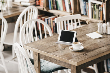Tisch in einem Café mit einer Tasse Kaffee und einem digitalen Tablet - KNSF000002