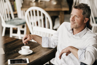 Businessman in cafe drinking coffee, daydreaming - KNSF000026