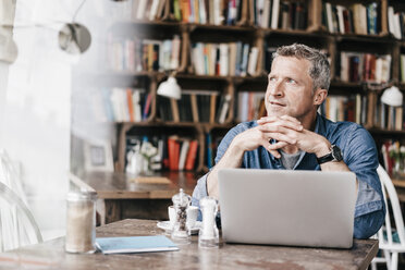 Geschäftsmann mit Laptop bei der Arbeit im Cafe - KNSF000044