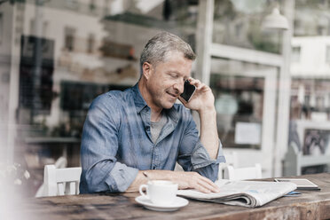 Älterer Mann sitzt im Café und telefoniert - KNSF000054