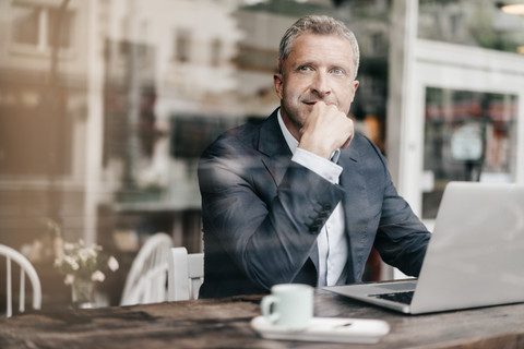 Businessman sitting in cafe, working stock photo