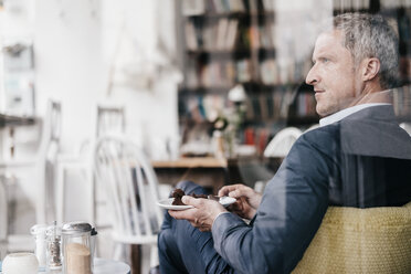 Businessman in cafe eating cake - KNSF000072