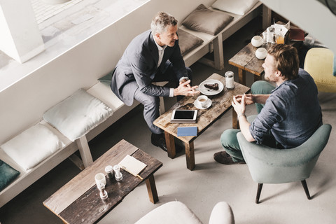 Geschäftsmann berät Kunden in einem Cafe, lizenzfreies Stockfoto