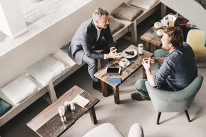 Businessman consulting customer in cafe - KNSF000085