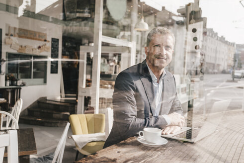 Geschäftsmann sitzt im Café und arbeitet - KNSF000093