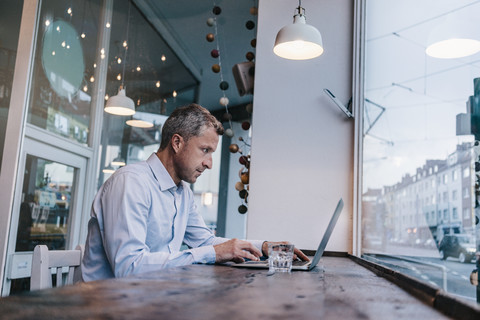 Geschäftsmann sitzt im Café und arbeitet, lizenzfreies Stockfoto