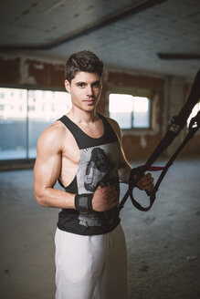 Young man exercising suspension training trx - RAEF001262