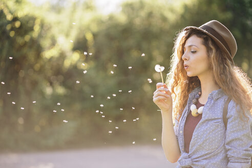 Young woman blowing dandelion - AKNF000059