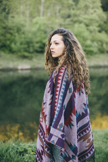 Portrait of young woman wearing patterned poncho - AKNF000062