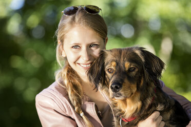 Portrait of happy woman with her mongrel - MIDF000741