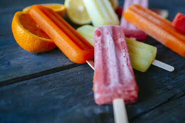 Eis aus Orange, Zitrone und Wassermelone auf blauem Holz - KIJF000519