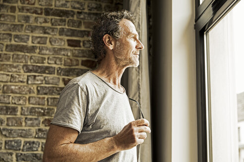 Man looking through window - FMKF002765