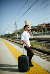 Junger Mann mit Handy am Bahnsteig - KIJF000536