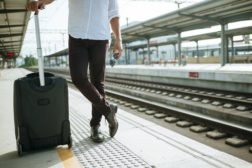 Mann mit Koffer wartet am Bahnsteig - KIJF000562