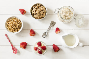 Schalen mit Hafervollkornkissen und Haferflocken, ein Glas Porridge, Erdbeeren und ein Milchkännchen - EVGF003013