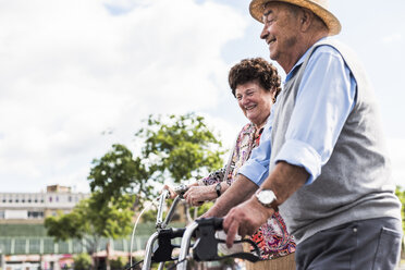 Glückliches Seniorenpaar mit Fahrrad und Rollator - UUF008046