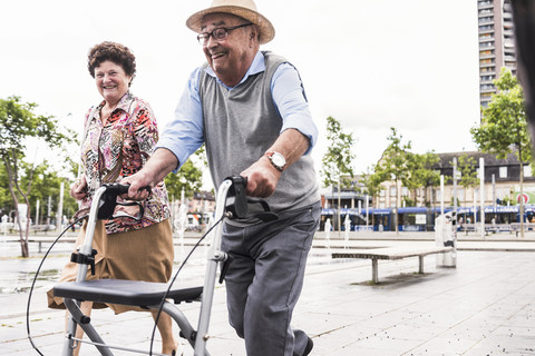 Älterer Mann benutzt Rollator, weil er vor seiner Frau wegläuft, lizenzfreies Stockfoto