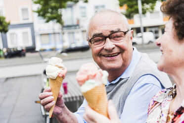 Porträt eines glücklichen älteren Mannes mit Eiswaffel, der seine Frau ansieht - UUF008053