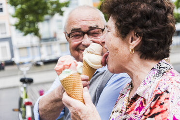 Senior couple enjoy eating ice cream together - UUF008054