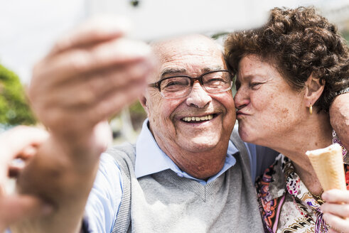 Porträt eines lächelnden älteren Mannes, der ein Selfie mit seiner Frau macht - UUF008056
